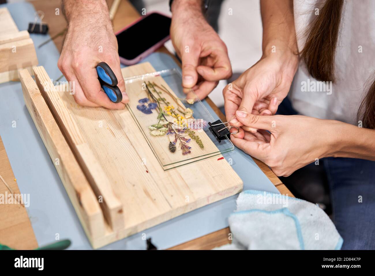 Une femme fixe des plaques de verre. Master class sur la création de cadre avec Herbarium en technique tiffany en vitrail. Herbarium de différentes plantes séchées Banque D'Images