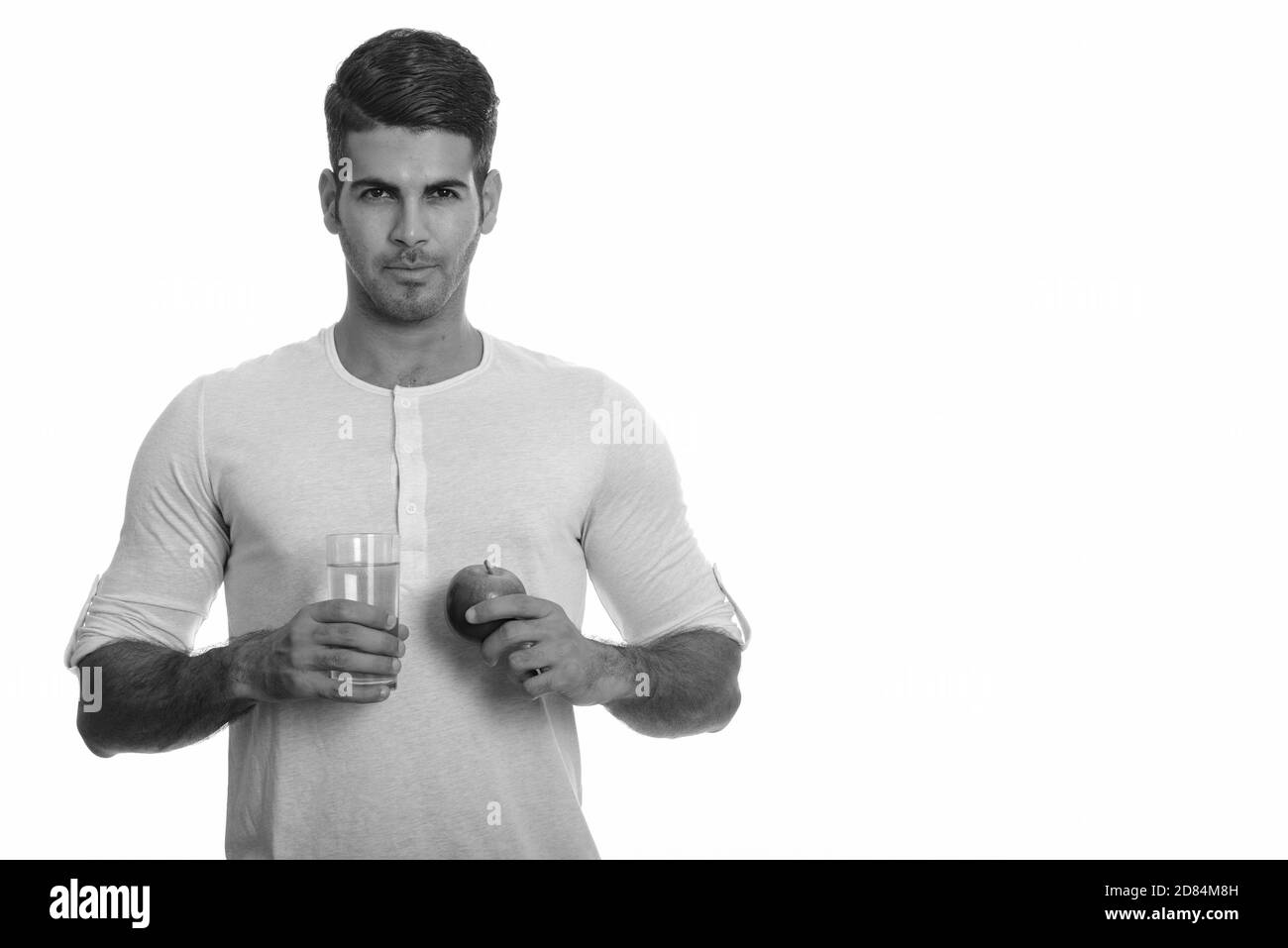 Jeune homme persan beau tenant un verre d'eau et de pomme Banque D'Images