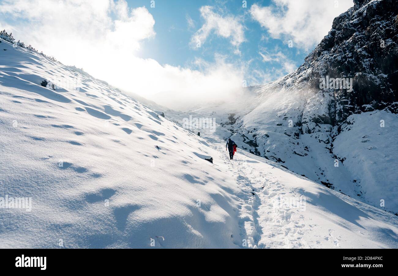Ascension des randonneurs jusqu'au sommet. Hiver glace et escalade de neige dans les montagnes. Un succès de l'alpiniste qui a atteint le sommet. Sports d'aventure en plein air Banque D'Images