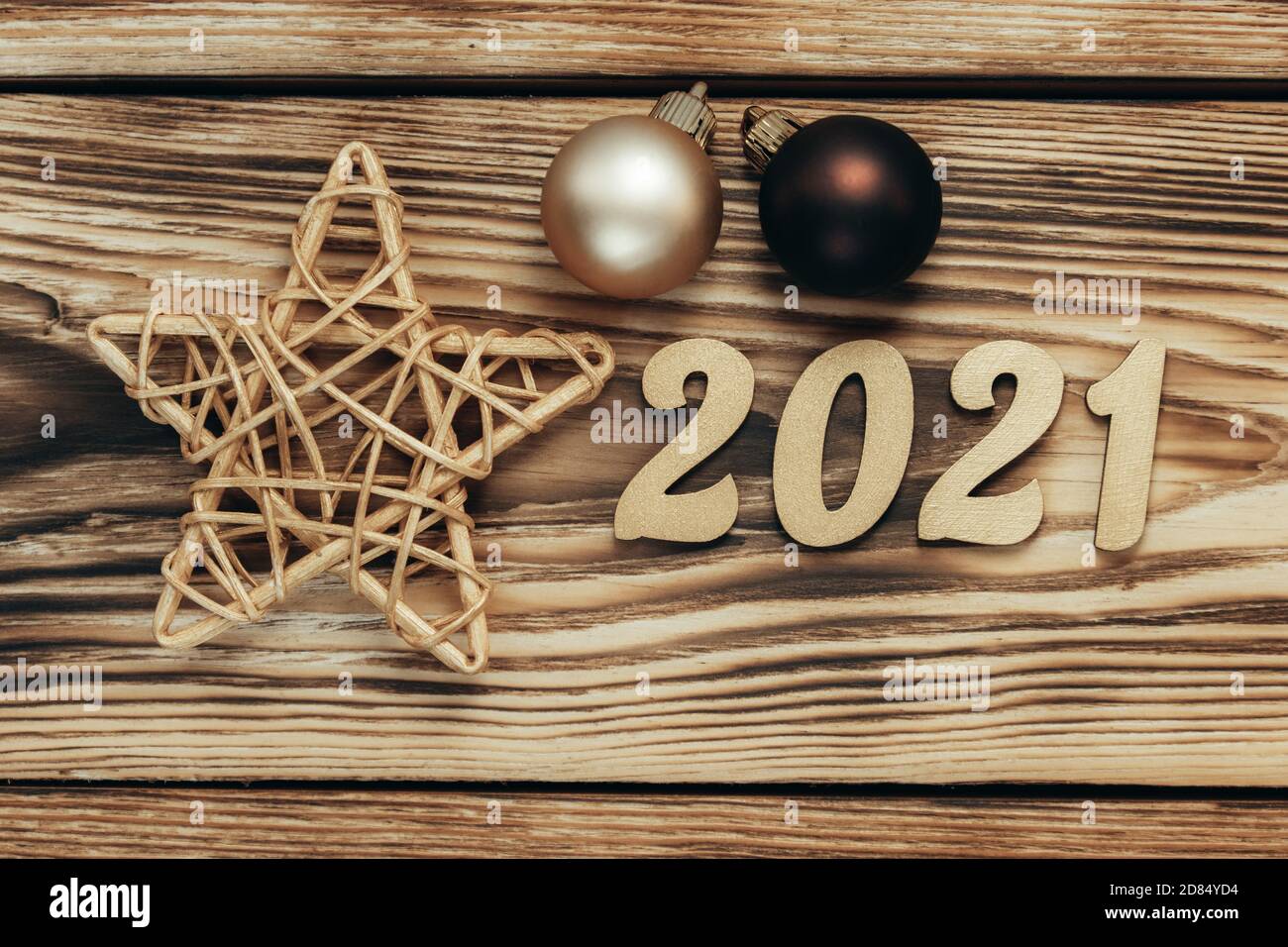 Carte de Noël avec chiffres dorés, boules et étoile sur fond de bois. Nouvelle année 2021. Fond de fête pour le nouvel an. Pose à plat. Vue de dessus. Banque D'Images