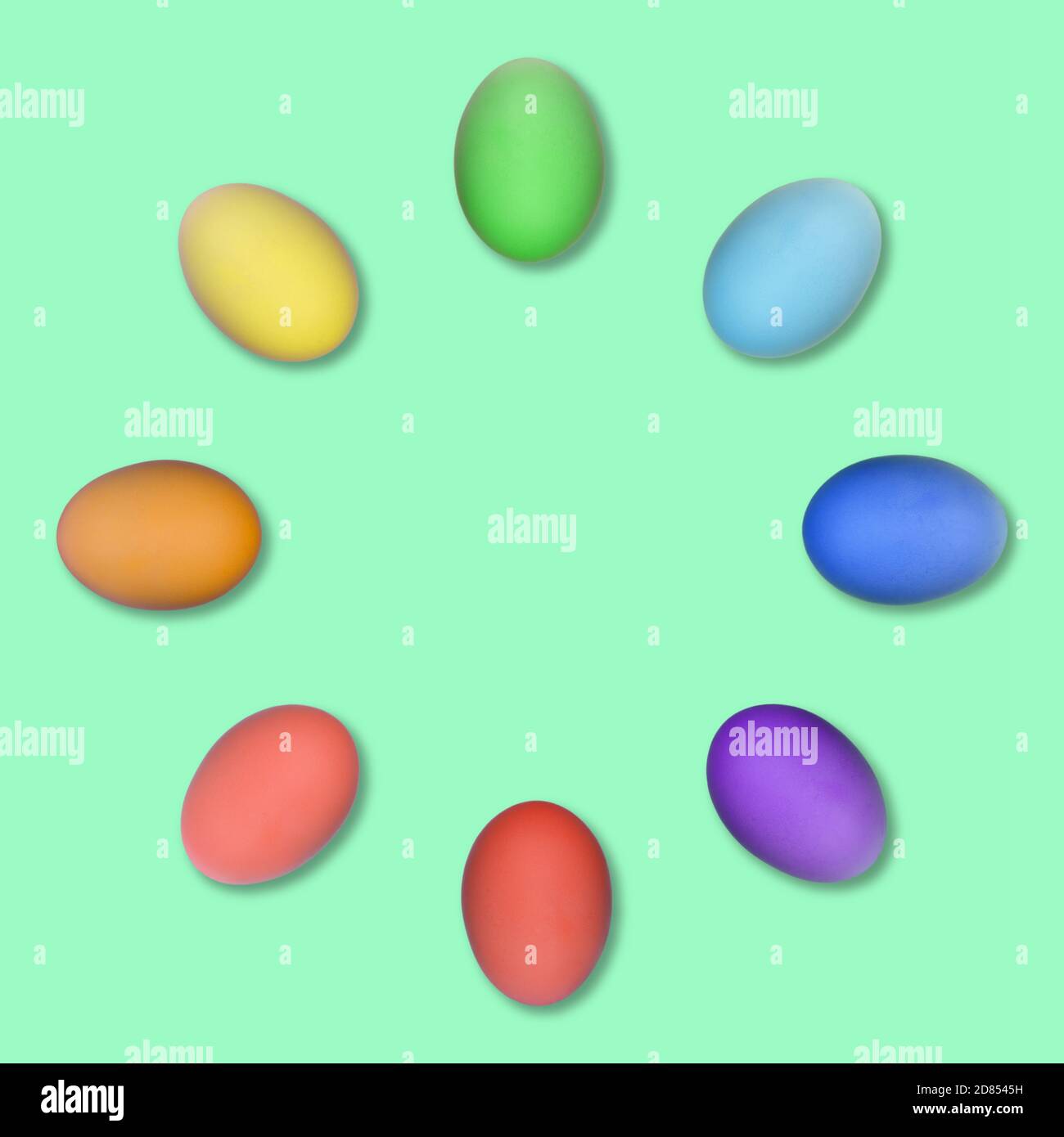Ensemble d'œufs de Pâques colorés regroupés dans un cercle isolé sur fond vert. Banque D'Images