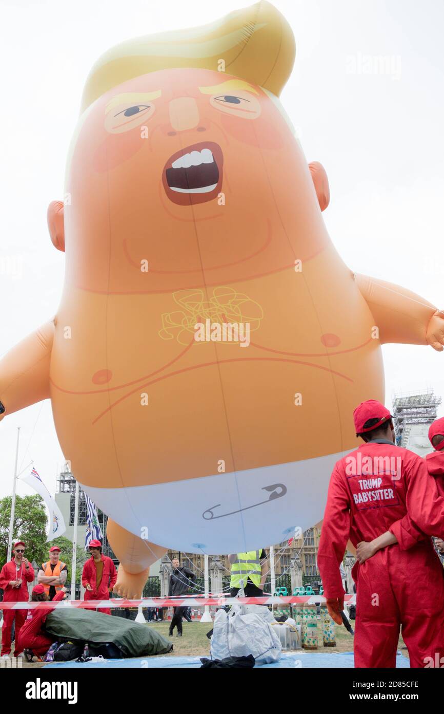 Londres, Royaume-Uni, 4 juin 2019 : les sitters de Trump Baby se tiennent devant la sqaure de Trump Baby Blimp au Parlement Banque D'Images