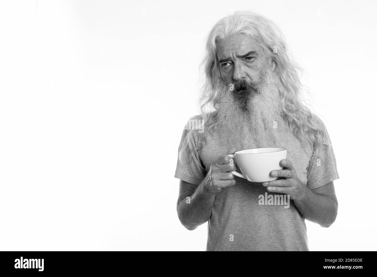 Studio shot of a souligné la haute homme barbu à la fatigue tout en holding Coffee cup Banque D'Images