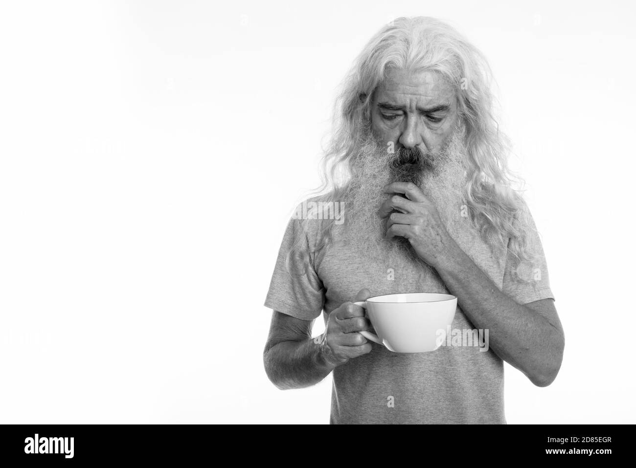 Studio shot of a souligné la haute barbu pense alors que holding Coffee cup Banque D'Images