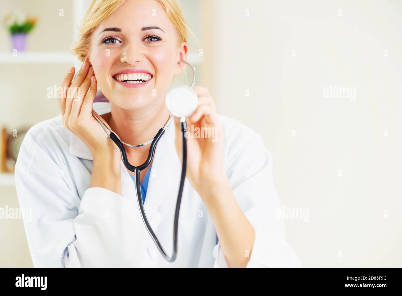 Jeune femme médecin stéthoscope de pointage à l'espace. Au point sélective face aux médecins. Soins médicaux concept. Banque D'Images