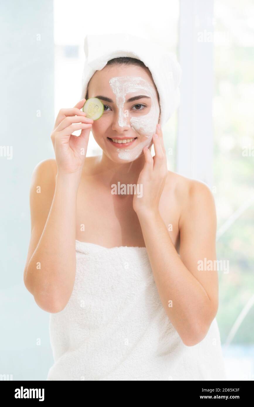 Belle femme ayant un traitement de masque facial avec l'extrait de crème de concombre montrant l'avantage du traitement de la nature. Anti-âge, soin du visage et Banque D'Images