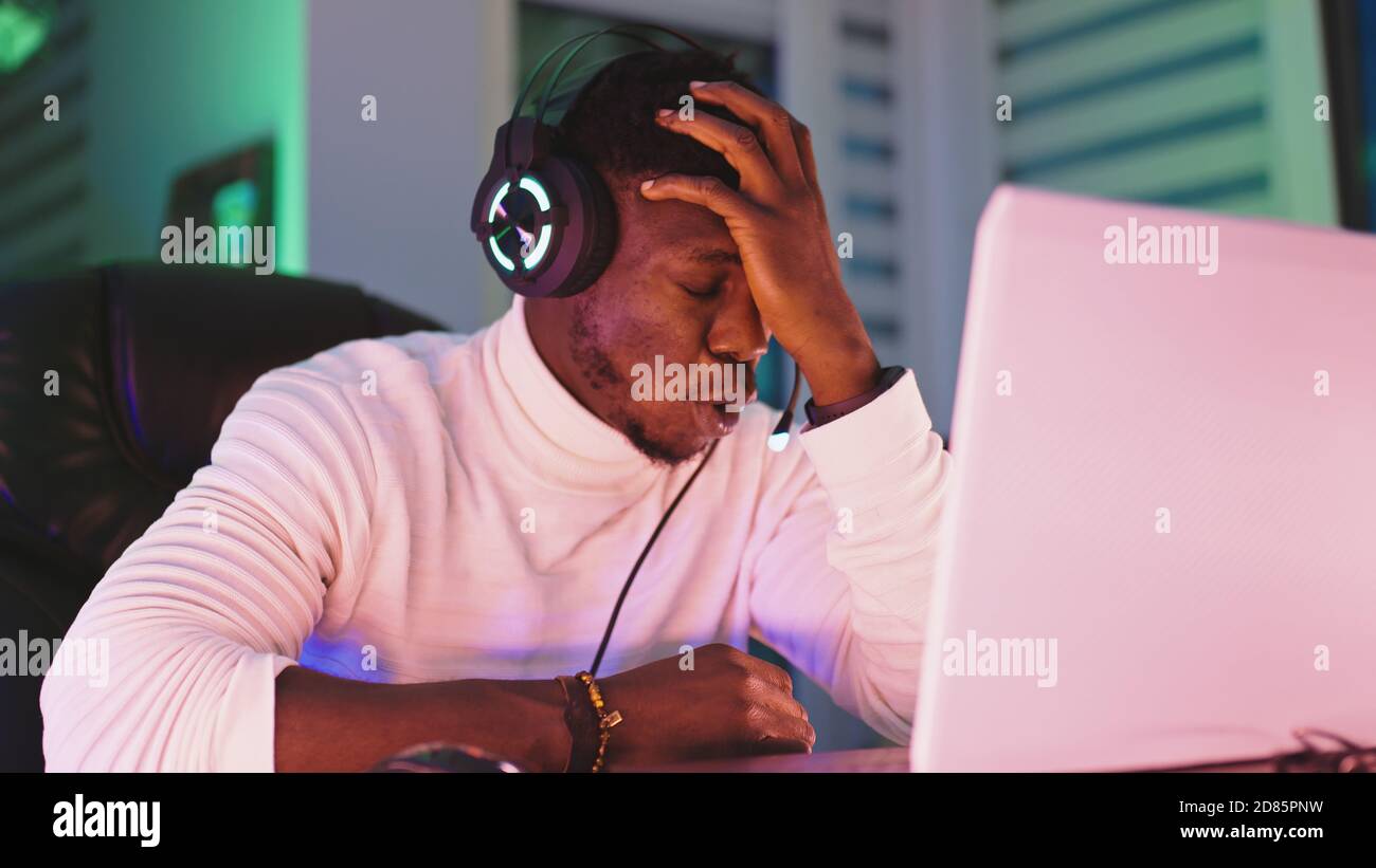 Portrait tourné de jeune homme noir déçu joueur de jeu professionnel perdant dans le jeu vidéo. Photo de haute qualité Banque D'Images