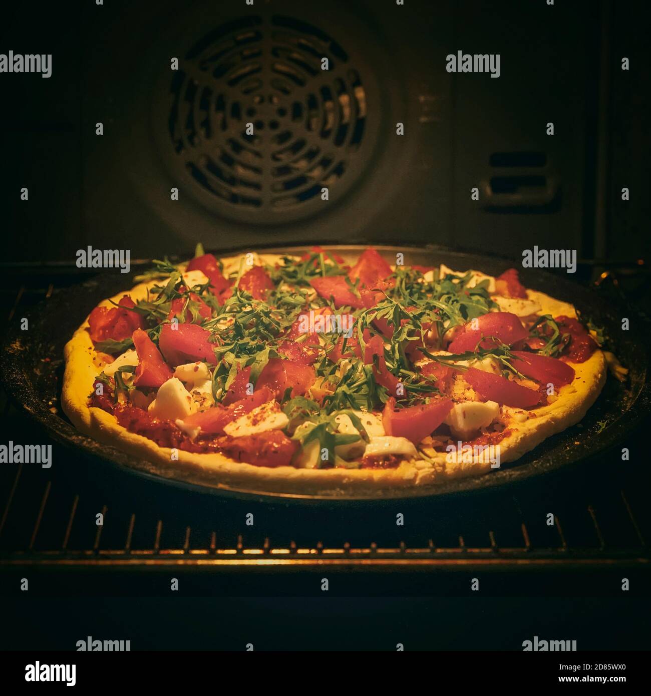 Faire cuire de la pizza au four. La nourriture. Cuisine maison. Pizza  délicieuse avec des ingrédients frais, des tomates, des arugula et du  fromage Photo Stock - Alamy