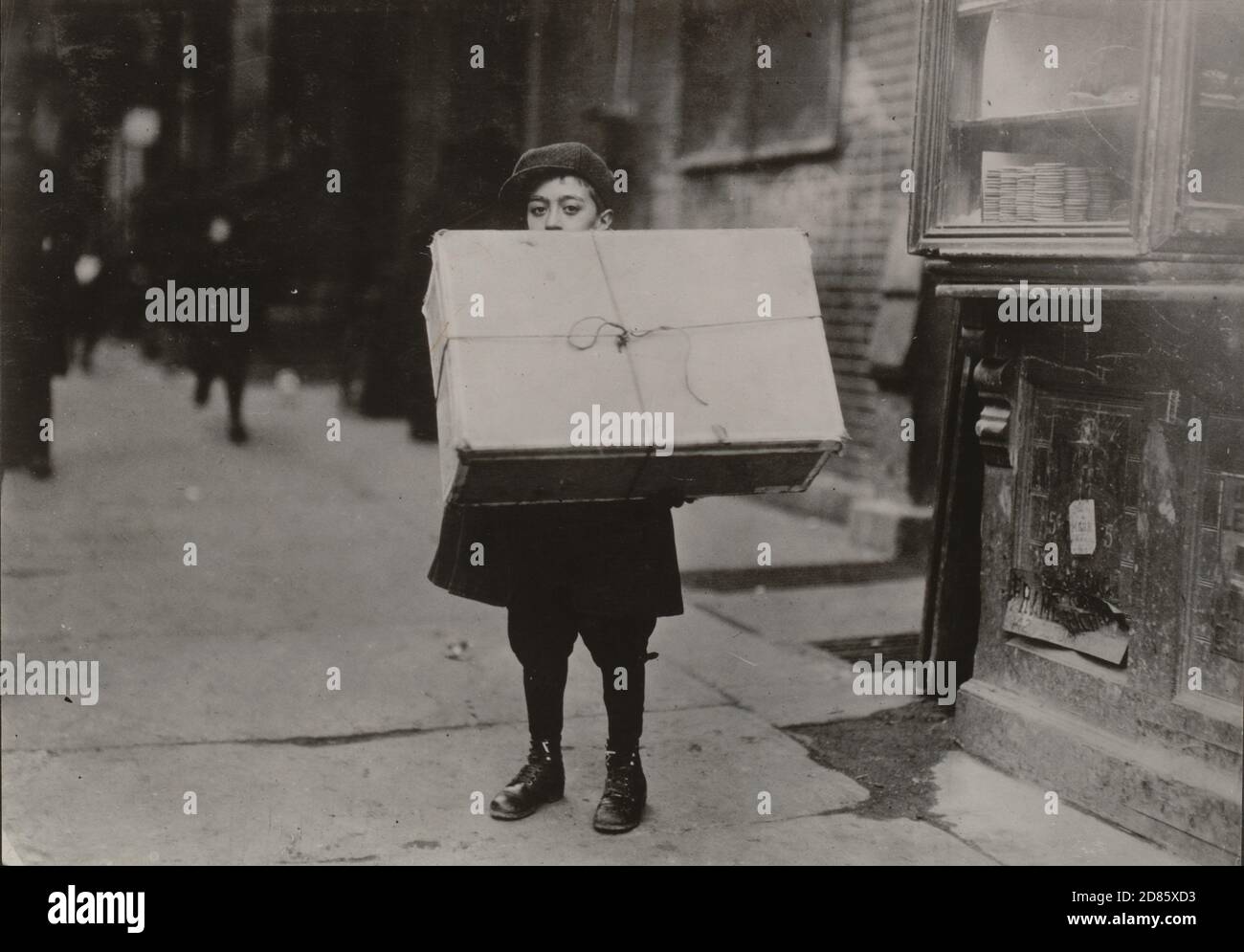 Photo d'époque Lewis W. Hine - Garçon avec un grand paquet. Ville de New York 1912. Banque D'Images