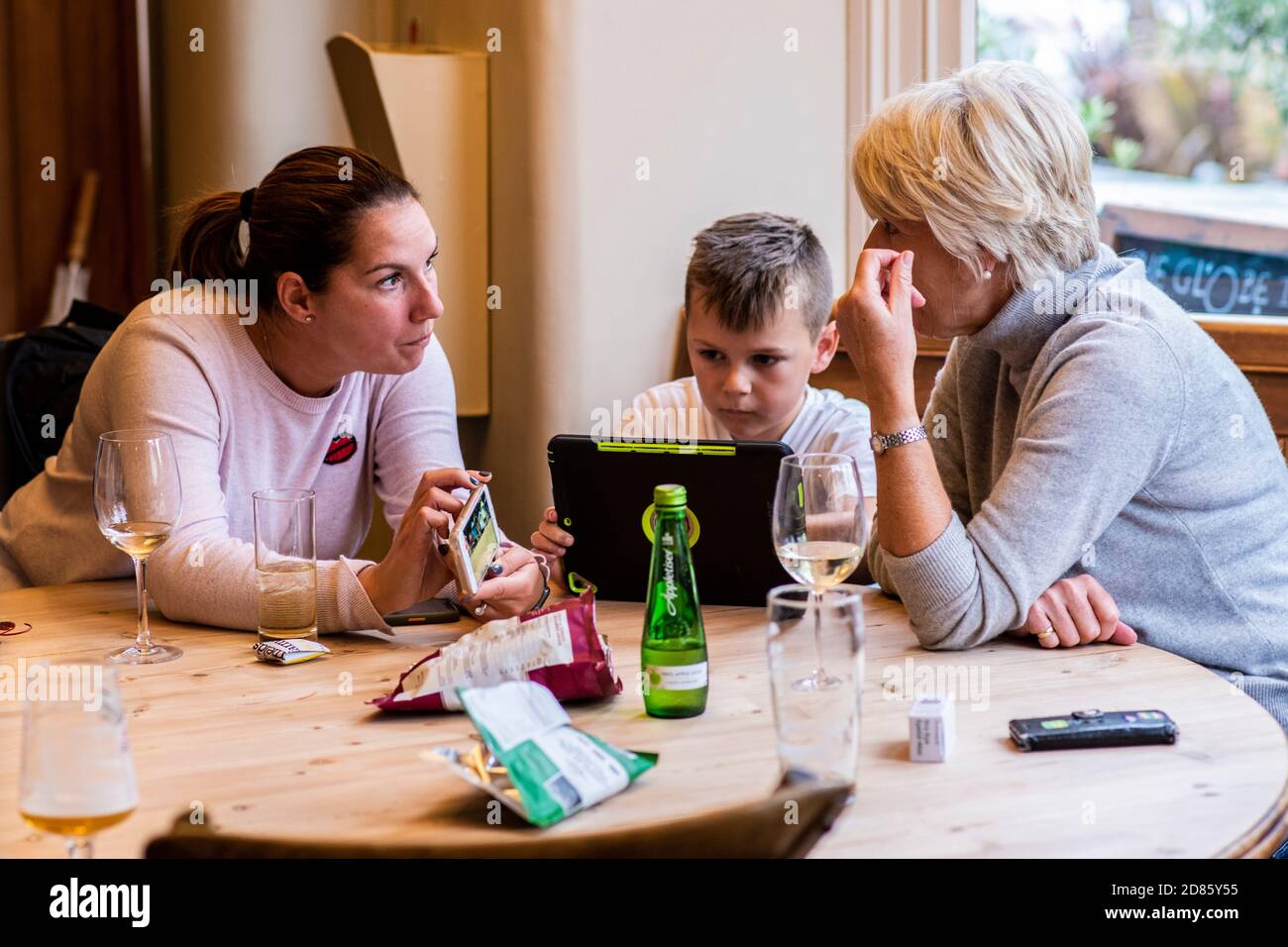 Famille au pub avec appareils numériques, Wells Next the Sea, Norfolk, Royaume-Uni Banque D'Images