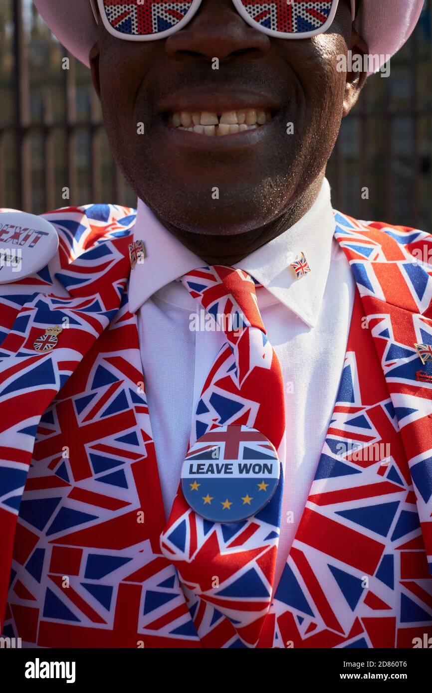 Brexitland - Grande-Bretagne du Brexit - UN vote en faveur du Brexit laisse un homme souriant dans un costume de drapeau de l'Union Jack devant Westminster Londres Royaume-Uni. 29 mars 2019 Banque D'Images