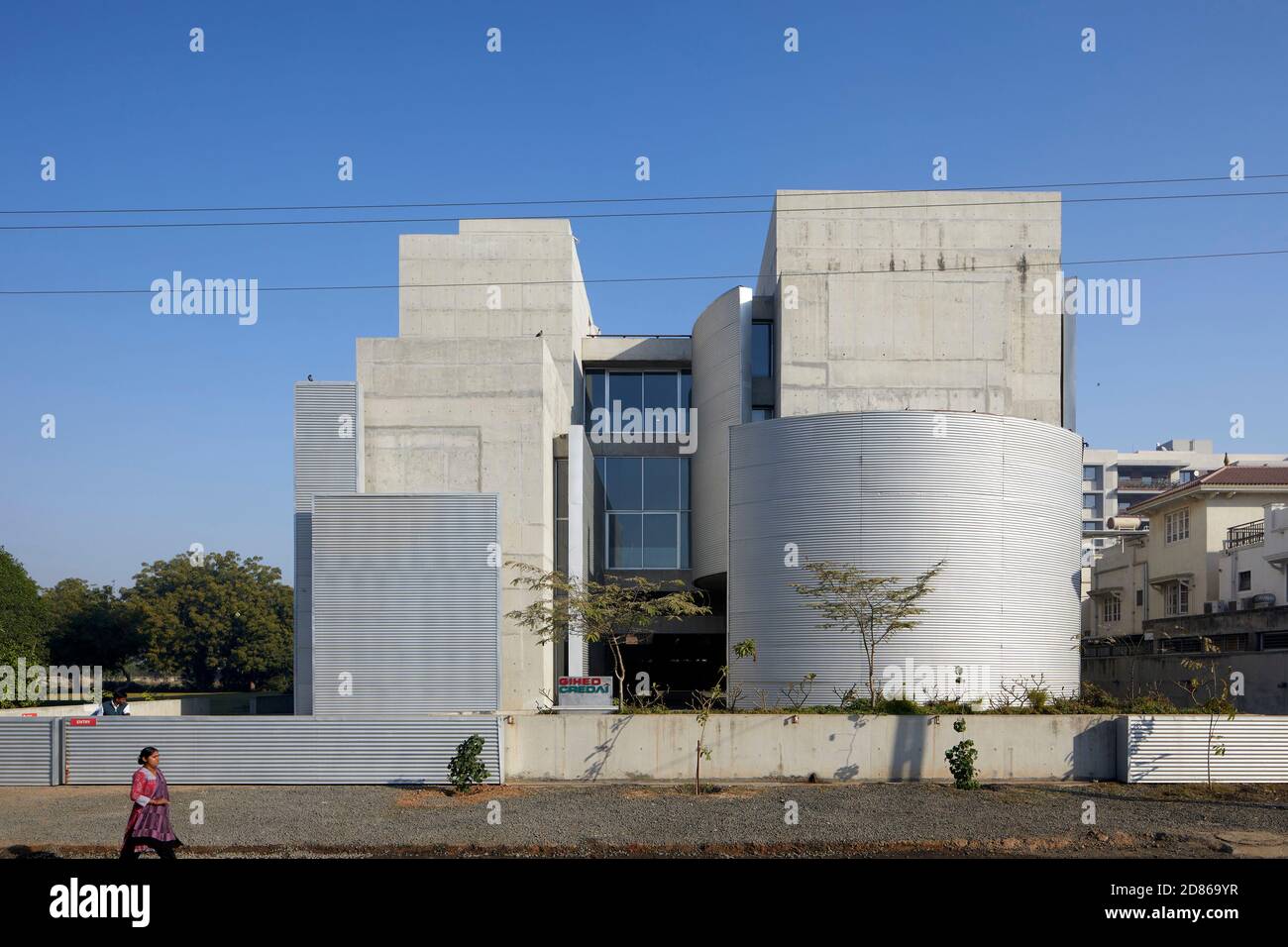 Vue extérieure globale avec murs en mouvement. Gihed Credai, Ahmedabad, Inde. Architecte: Matharoo Associates, 2020. Banque D'Images