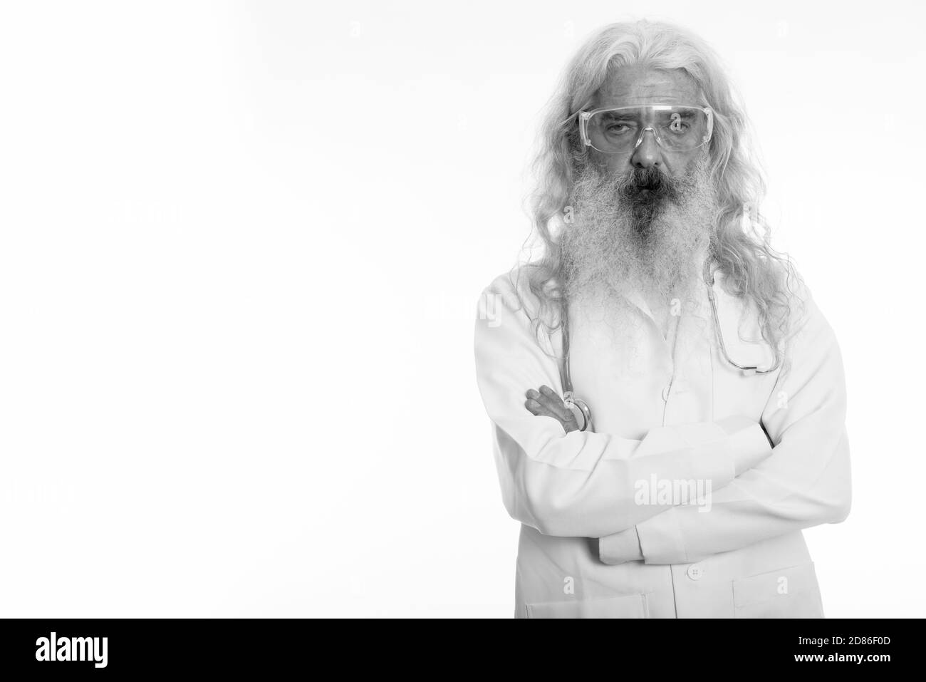Studio shot of senior homme barbu médecin portant des lunettes avec les bras croisés Banque D'Images
