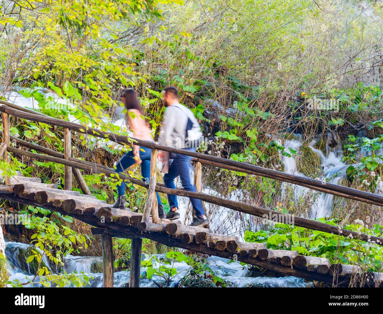 Visiteurs jeunes couples marchant flou exposition longue dans les lacs de Plitvice Parc national situé en Croatie Europe Banque D'Images