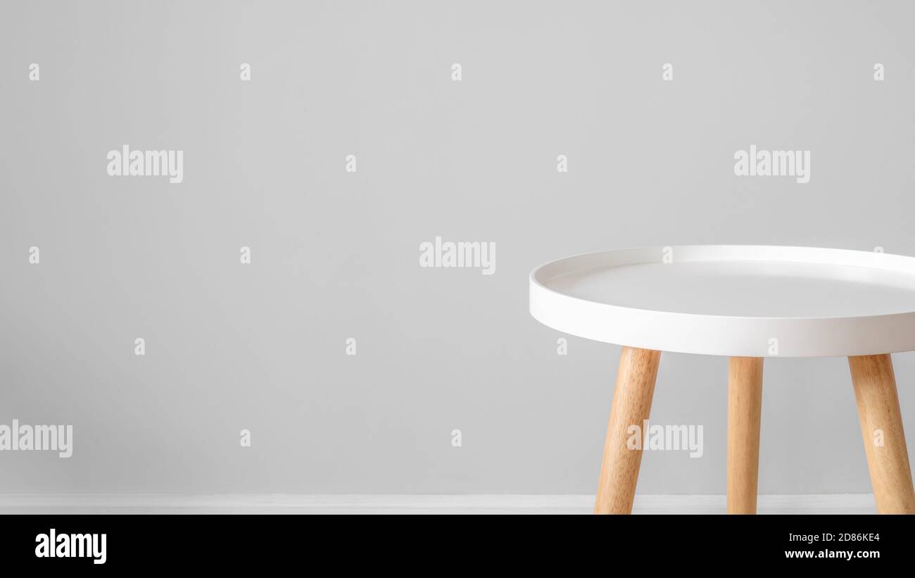 Vider la table à café blanche devant le mur gris. Style scandinave, minimalisme dans la maison, vie tranquille, toile de fond et espace de copie pour la publicité et Banque D'Images