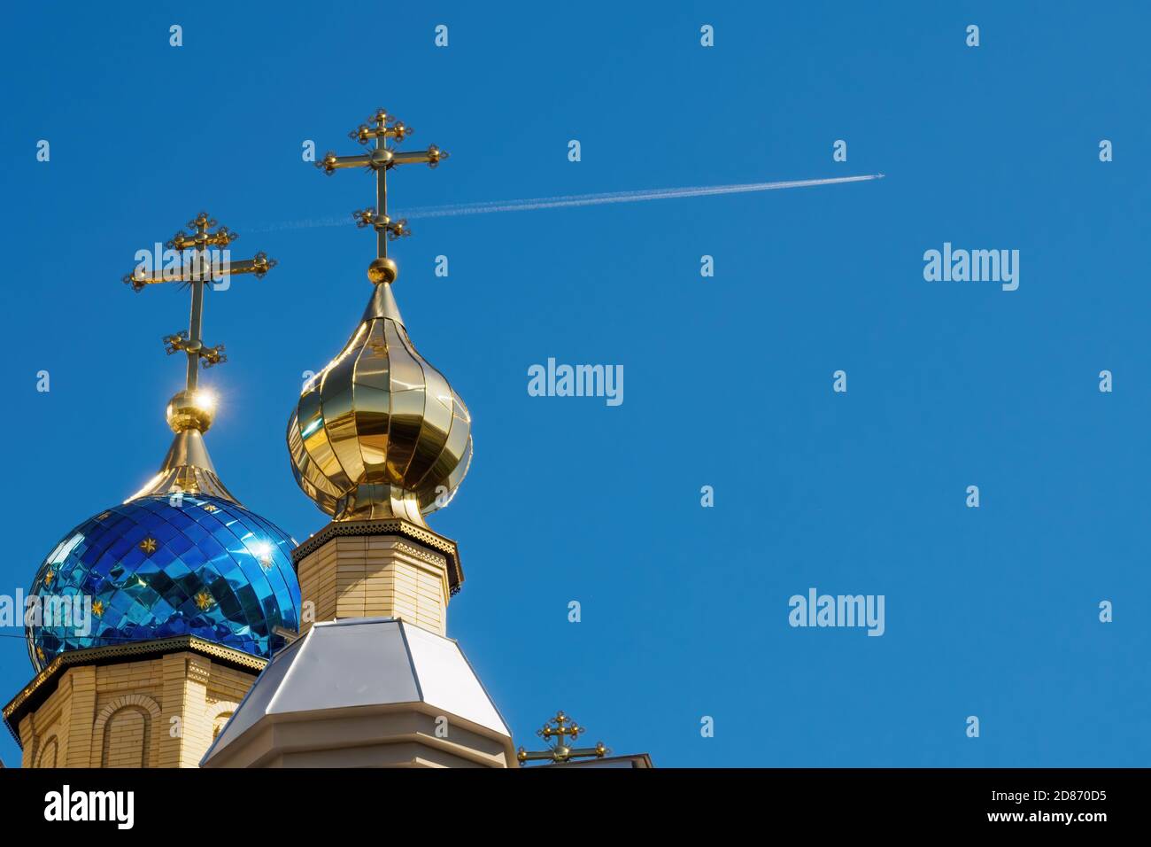 Dômes du temple avec croix contre ciel bleu et avion volant avec tracé blanc. Église orthodoxe et avion volant Banque D'Images