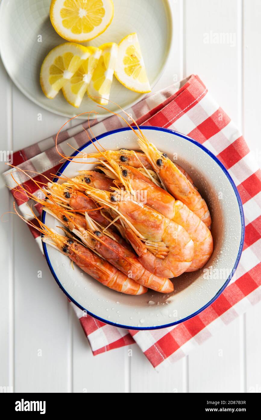 Crevettes tigrées bouillies dans un bol sur table blanche. Vue de dessus. Crevettes savoureuses. Banque D'Images