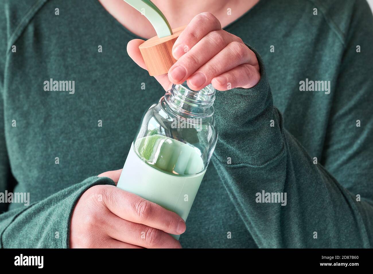 Bouteille de boisson réutilisable dans les mains des femmes. Mode de vie zéro gaspillage, concept de consommation consciente. Banque D'Images