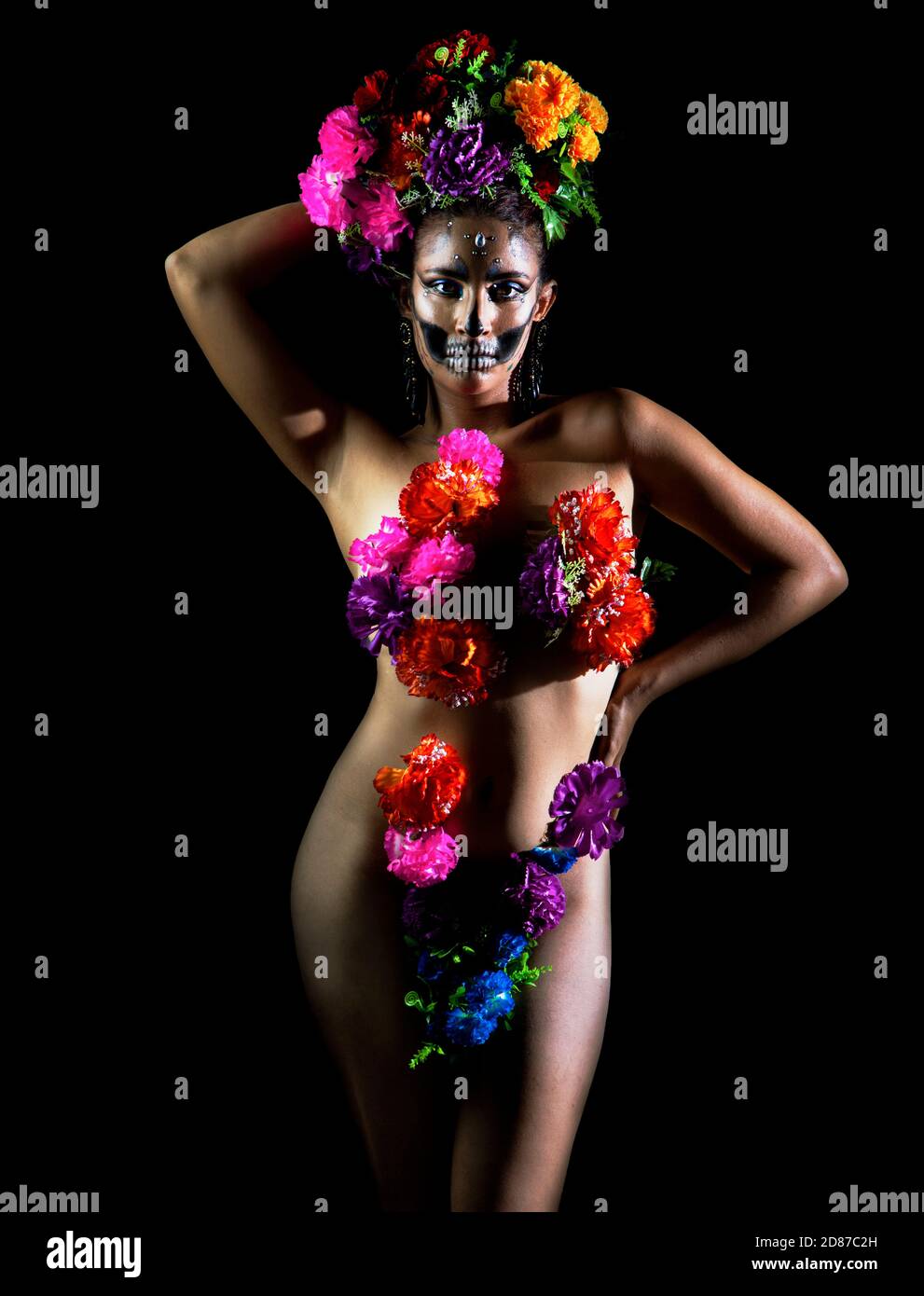 Nu Catrina couvrant son corps avec des fleurs dans l'obscurité de la nuit Banque D'Images