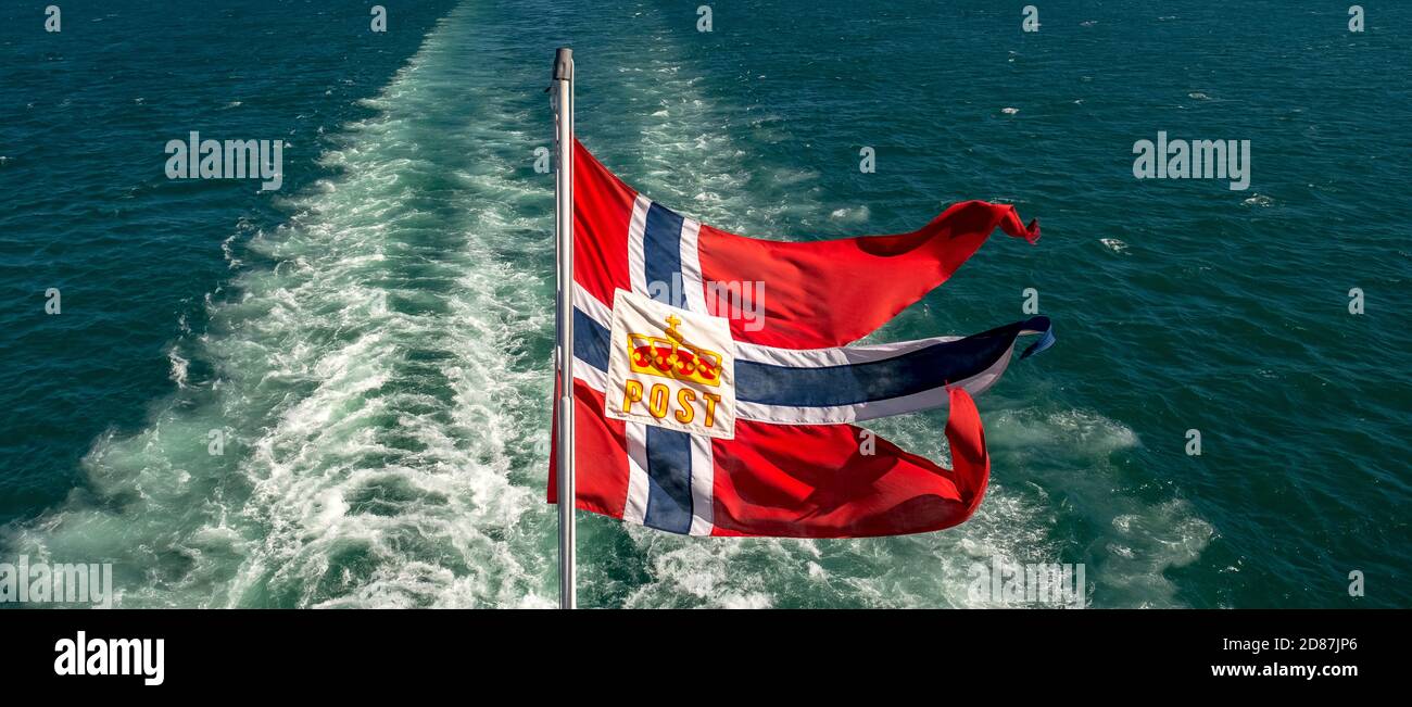 Le symbole de poste sur le drapeau norvégien d'un navire Hurtigruten, spray moussant, Trondheimfjord, Agdenes, Trøndelag, Norvège, Scandinavie, Europe, tri aventure Banque D'Images