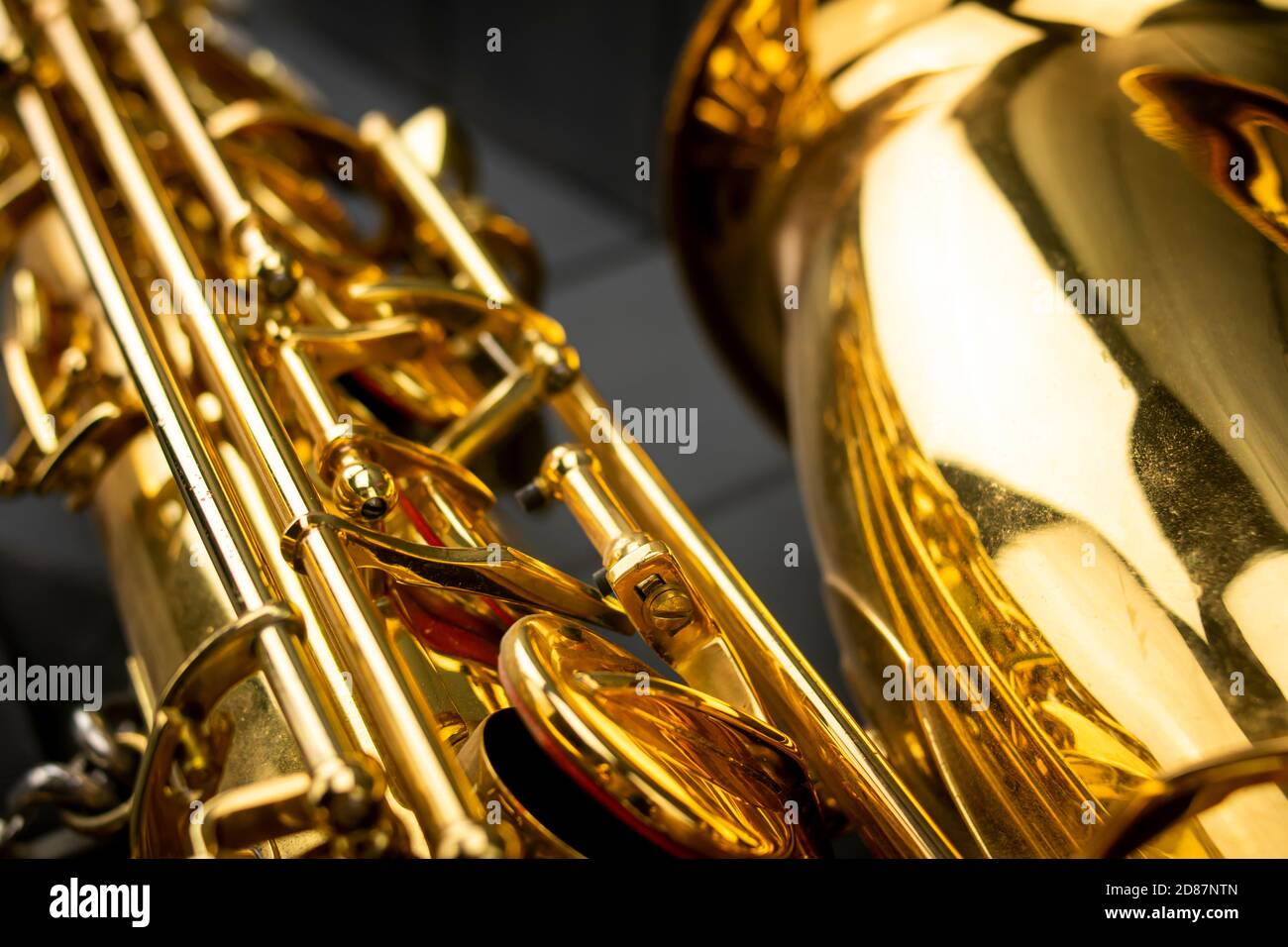 Corps, tiges, clés et cloche d'un saxophone doré sur fond gris en bois Banque D'Images