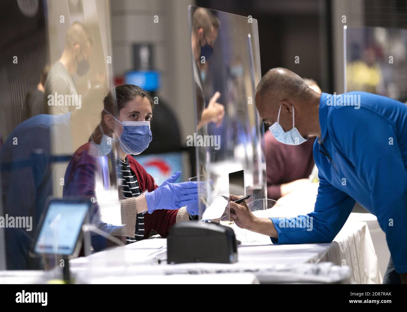 Washington, États-Unis. 27 octobre 2020. Une personne s'enregistre derrière un verre protecteur le premier jour du vote par anticipation à Washington, DC, le mardi 27 octobre 2020. Le vote par anticipation se poursuit dans la plupart des pays lors de l'élection présidentielle de 2020. Photo de Kevin Dietsch/UPI crédit: UPI/Alay Live News Banque D'Images