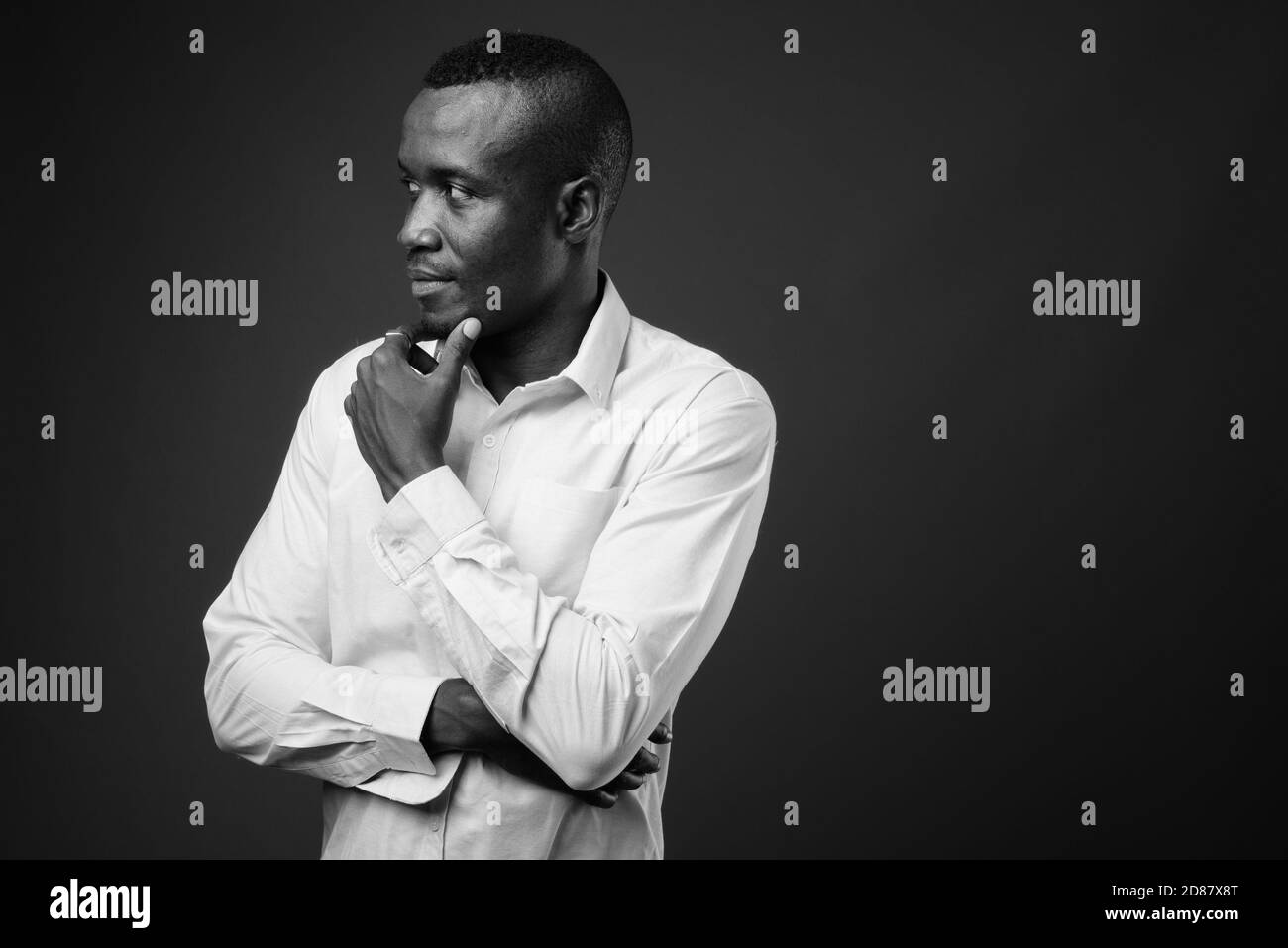 Studio de photo de jeune homme d'affaires africain sur fond gris Banque D'Images