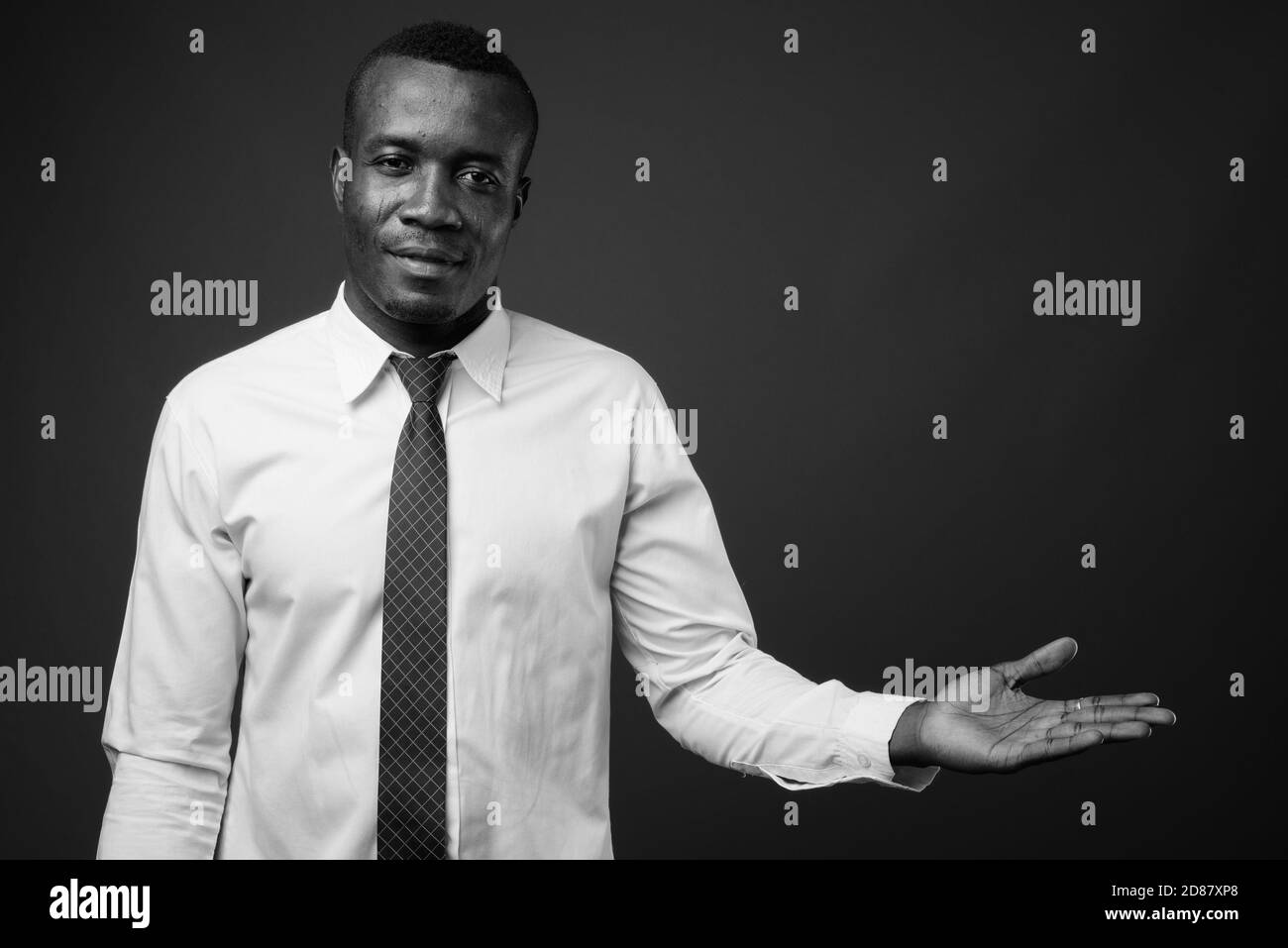 Studio de photo de jeune homme d'affaires africain sur fond gris Banque D'Images