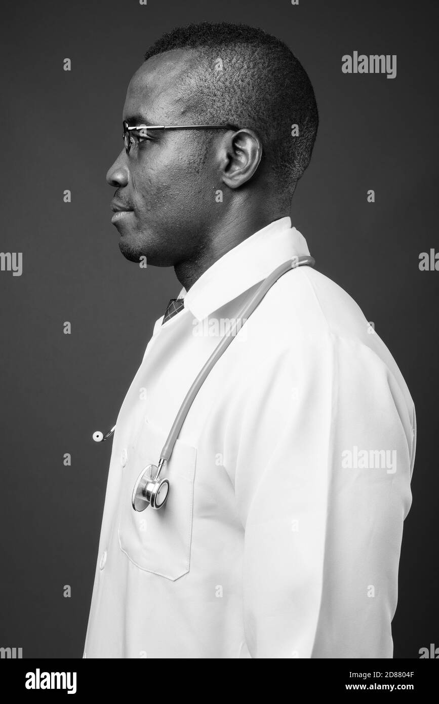 Studio de prise de vue d'un jeune homme africain médecin sur fond gris Banque D'Images