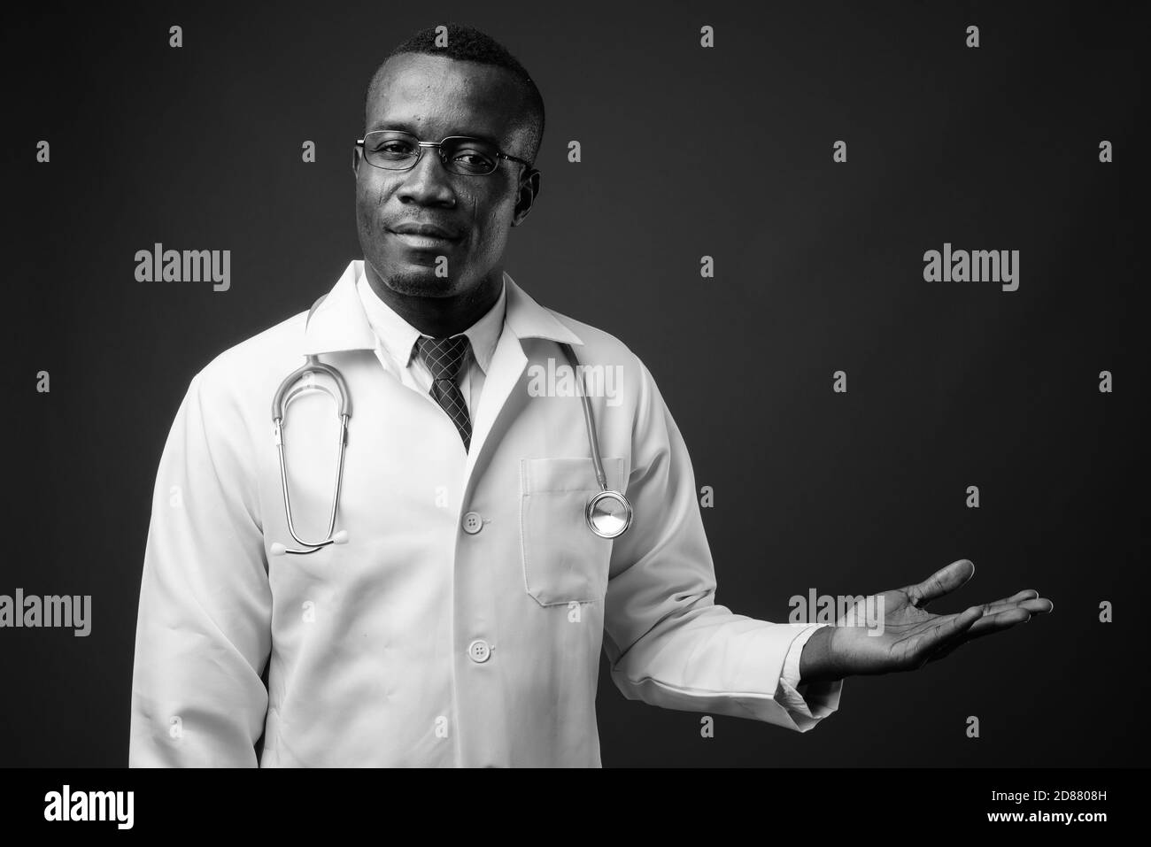 Studio de prise de vue d'un jeune homme africain médecin sur fond gris Banque D'Images