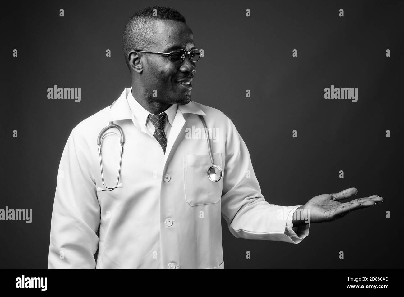 Studio de prise de vue d'un jeune homme africain médecin sur fond gris Banque D'Images