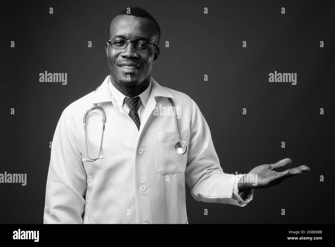 Studio de prise de vue d'un jeune homme africain médecin sur fond gris Banque D'Images