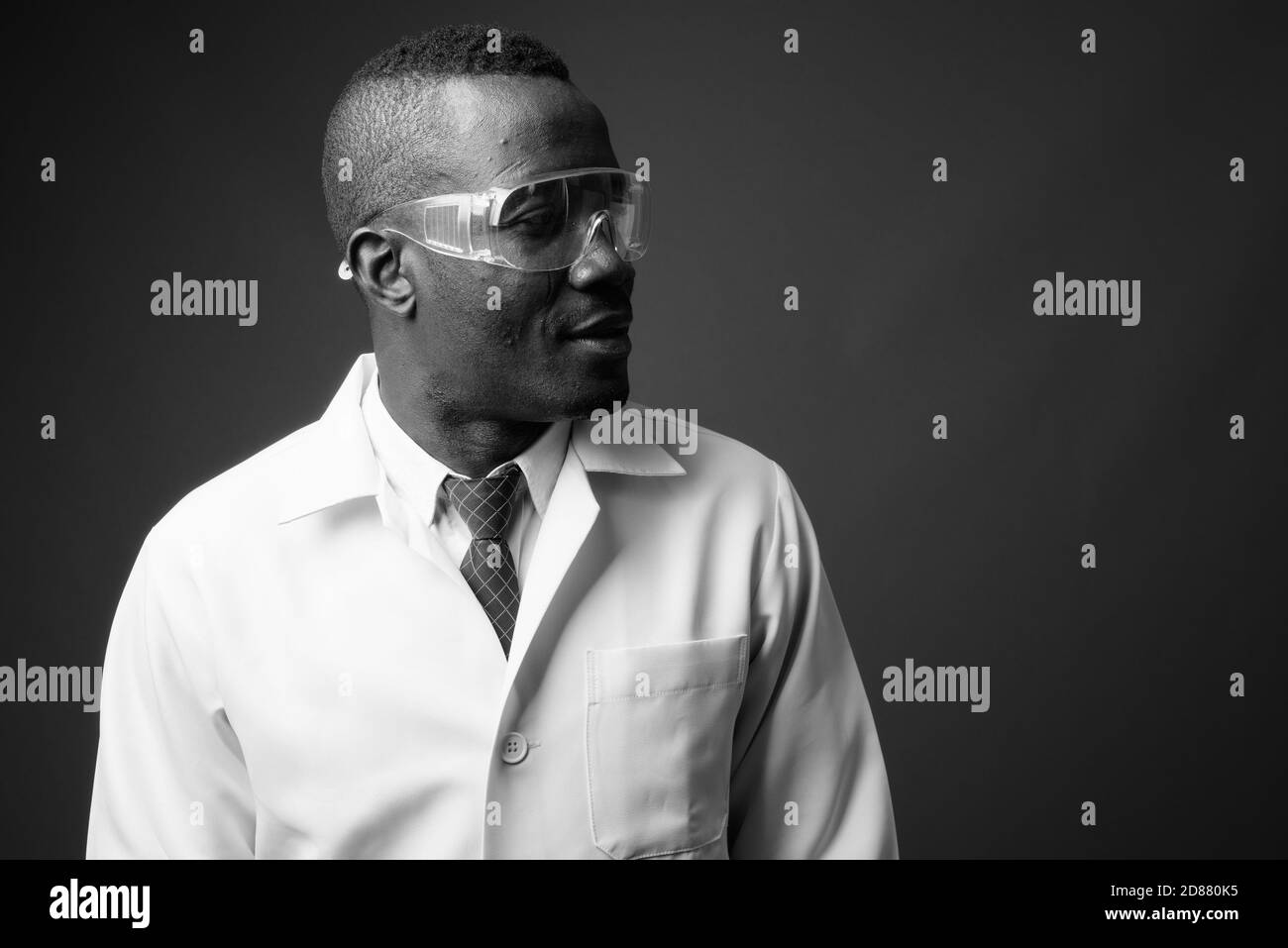 Studio de prise de vue d'un jeune homme africain médecin sur fond gris Banque D'Images