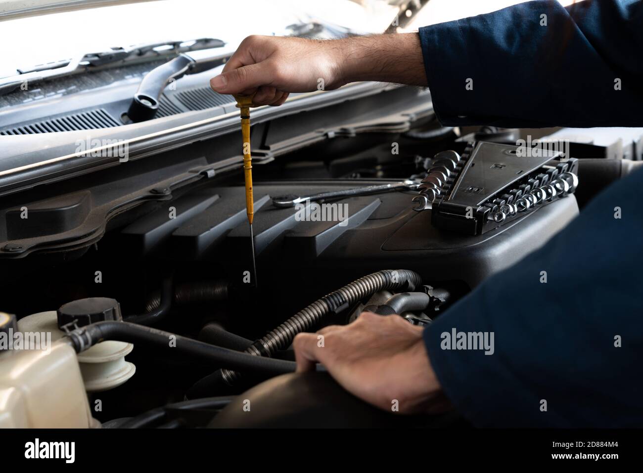 Mécanicien professionnel fournissant des services de réparation et d'entretien de voitures dans le garage automobile. Concept d'affaires de service de voiture. Banque D'Images