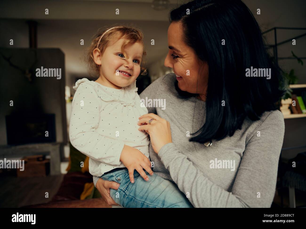 Mère et fille gaies jouant et riant à cause de chatouilles se tenir dans le salon à la maison Banque D'Images