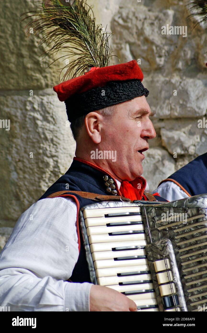 Un homme polonais plus âgé chante et joue l'accordéon dans une rue de la vieille ville de Cracovie, en Pologne, sur 13 mars 2010. Banque D'Images