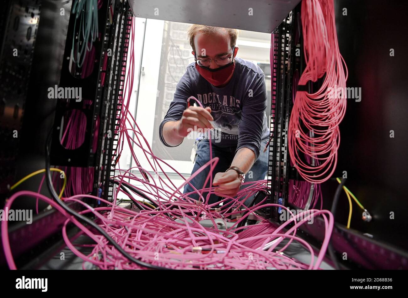 Berlin, Allemagne. 22 octobre 2020. L'administrateur système Fabian Sawall tire les câbles à fibre optique des périphériques de stockage de masse du centre de données Deutsche Bahn. Deux ans plus tôt que prévu, Deutsche Bahn a fermé ses propres centres de données et déplacé l'ensemble de ses SERVICES INFORMATIQUES vers le cloud. Credit: Britta Pedersen/dpa-Zentralbild/dpa/Alay Live News Banque D'Images