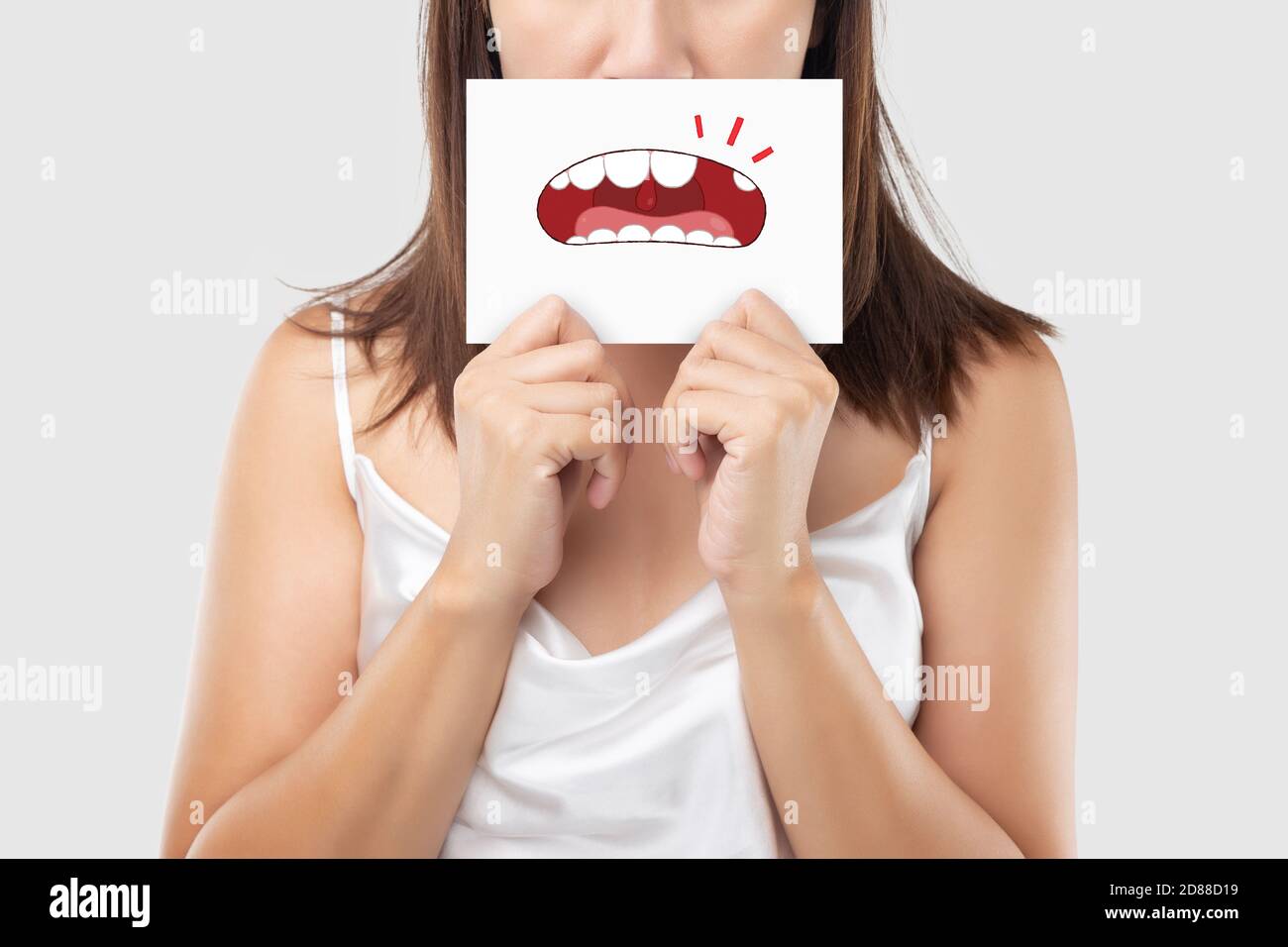Asian Woman in the red shirt tenant un papier brun avec la dent cassée caricature photo de sa bouche contre l'arrière-plan gris, dégradés, la dent Banque D'Images