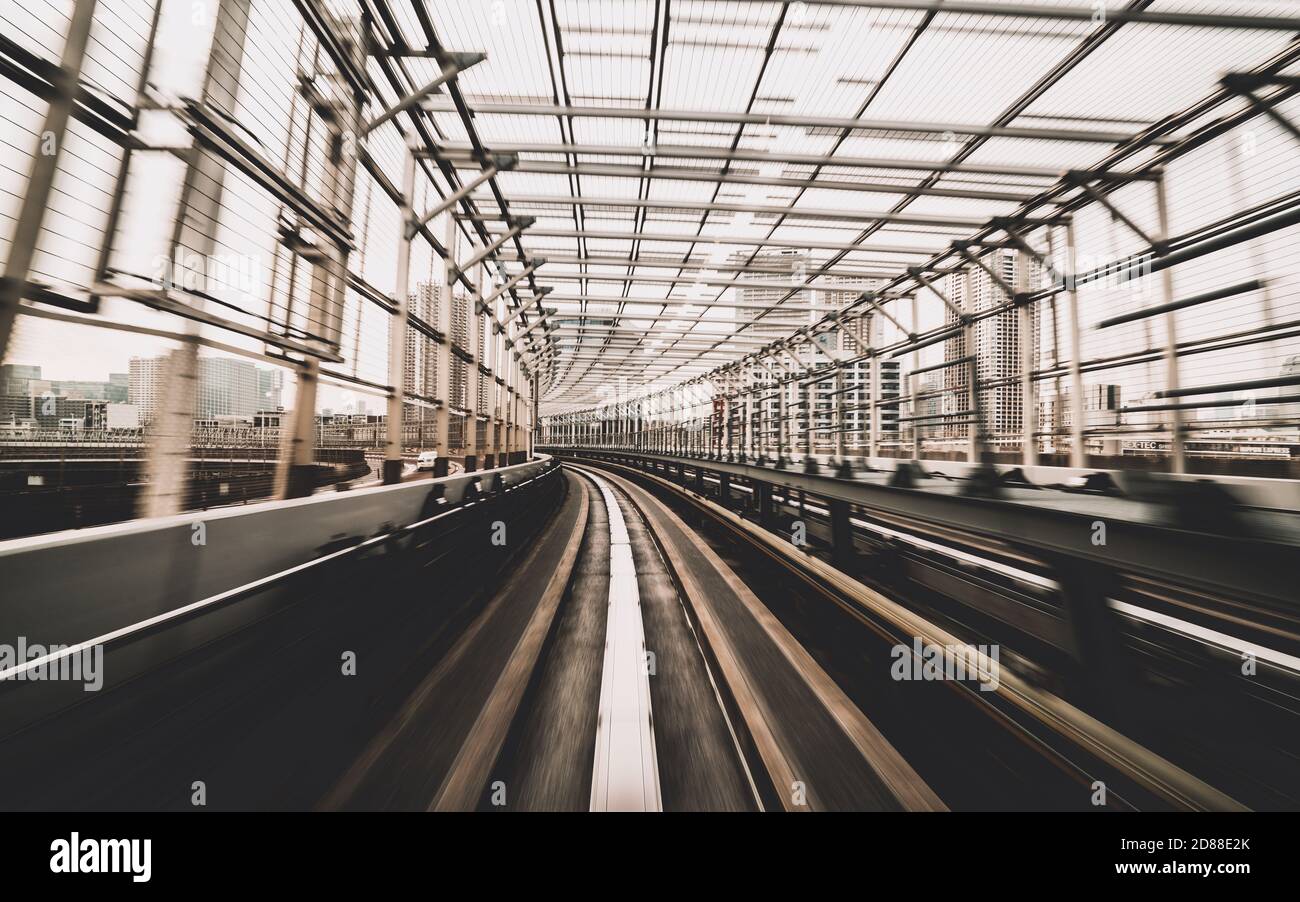 Vue de face du train en mouvement dans le tunnel ferroviaire de la ville avec un flou de mouvement modéré et un filtre de couleur sépia. Concept de transport et arrière-plan flou de mouvement Banque D'Images