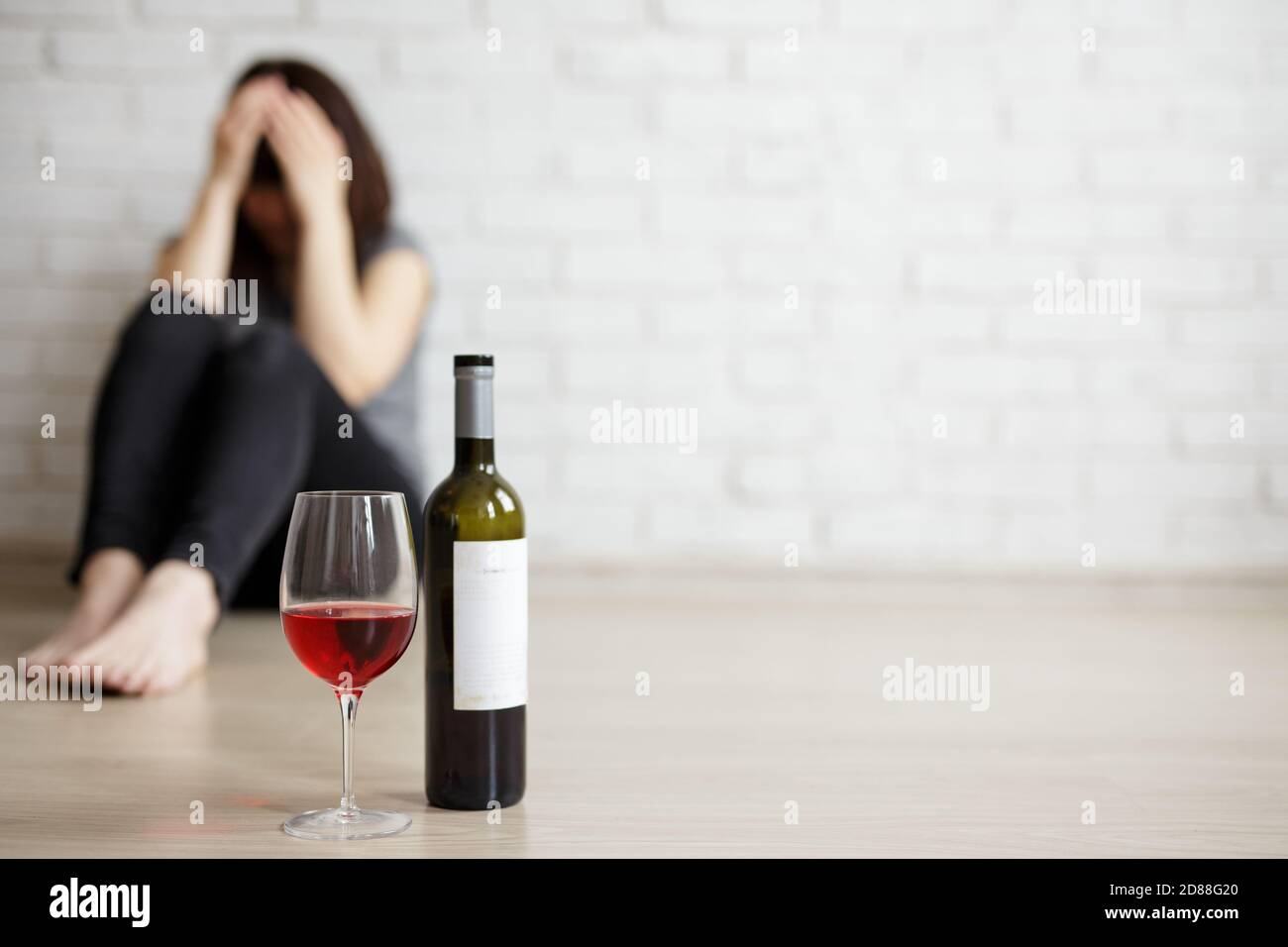 alcoolisme féminin, relation, divorce et la dépression concept - gros plan  du verre et bouteille de vin et femme stressée pleurant et assis sur la fl  Photo Stock - Alamy