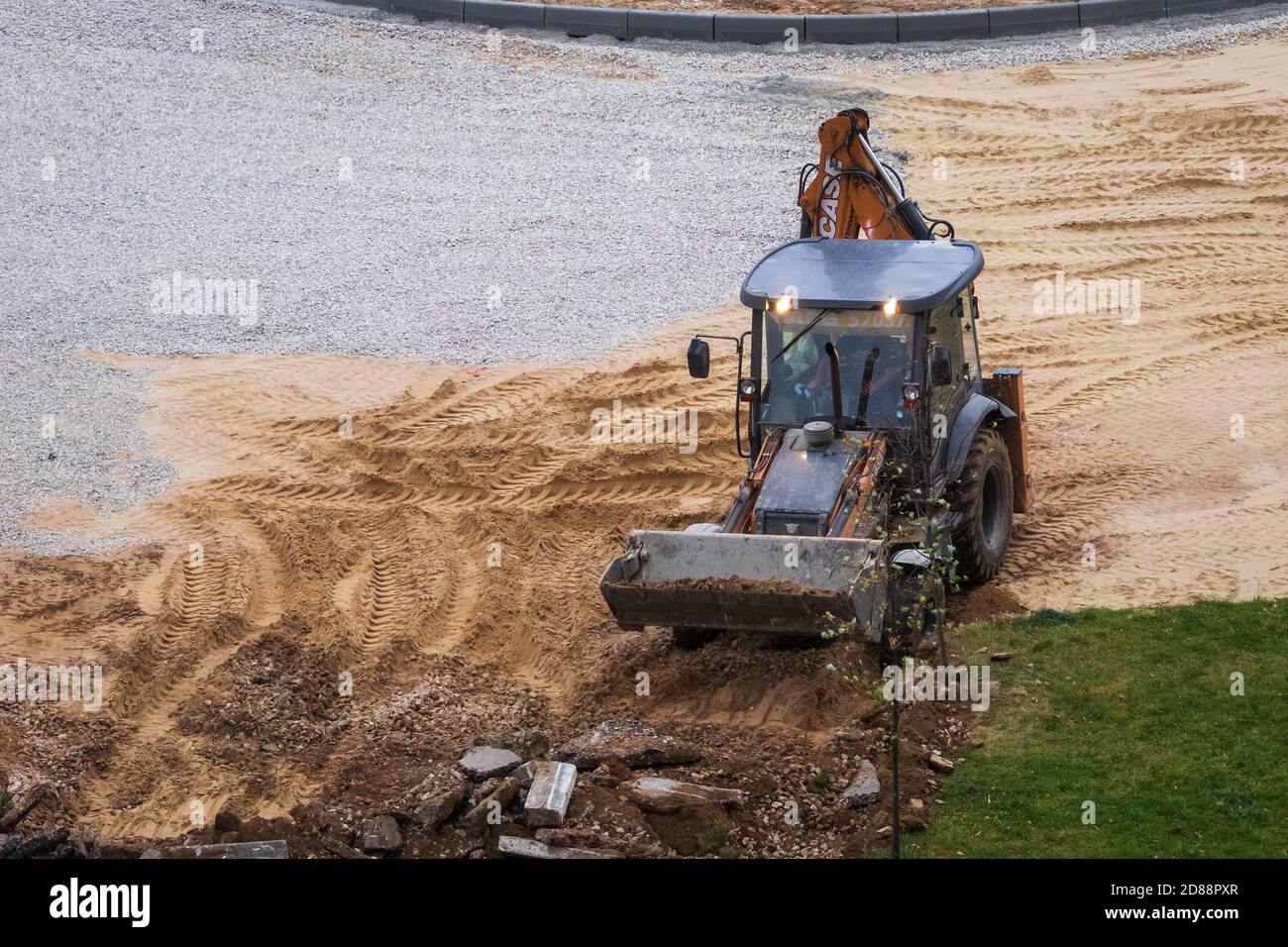 Russie, Kaluga - 27 OCTOBRE 2020 : tracteur brisant l'ancien asphalte avec un godet avant la construction d'une nouvelle route. Banque D'Images