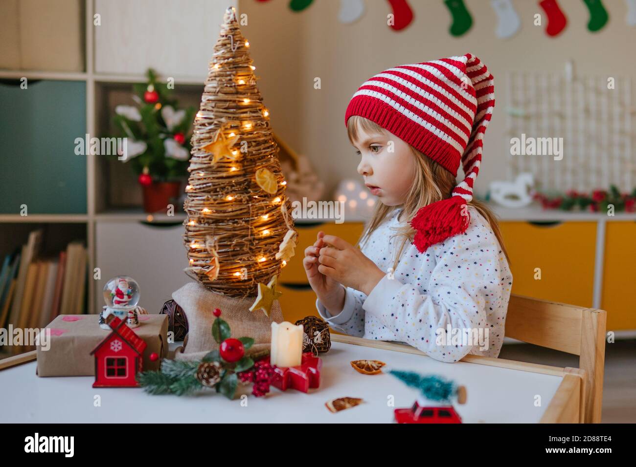 Petite fille décorée arbre de Noël éco intérieur Banque D'Images