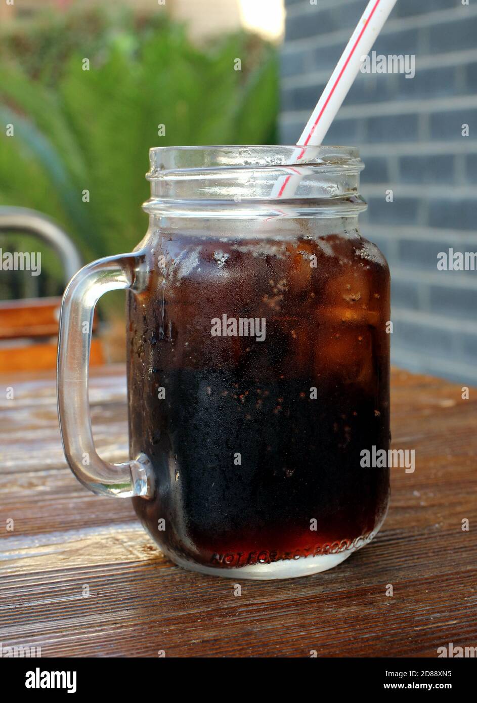 Soda dans un pot en verre avec glace et paille Banque D'Images