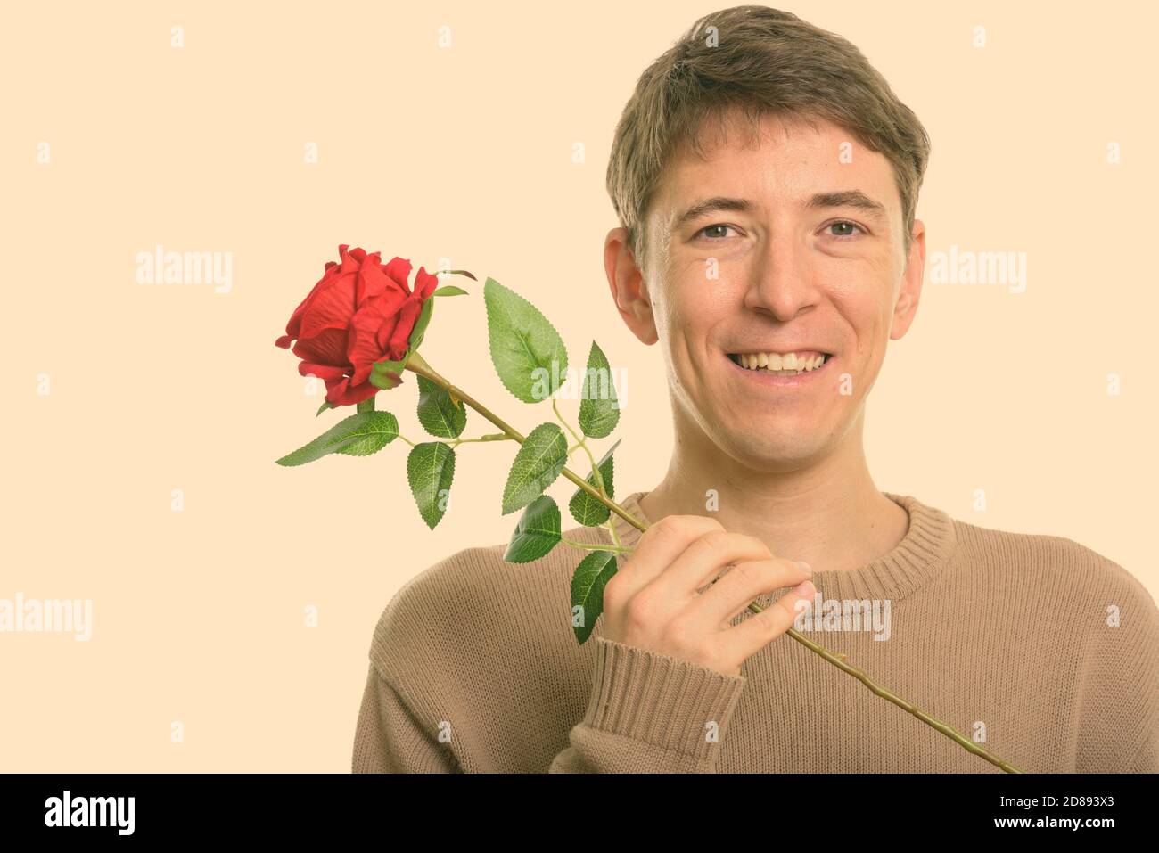 Close up of happy man smiling while holding red rose Banque D'Images