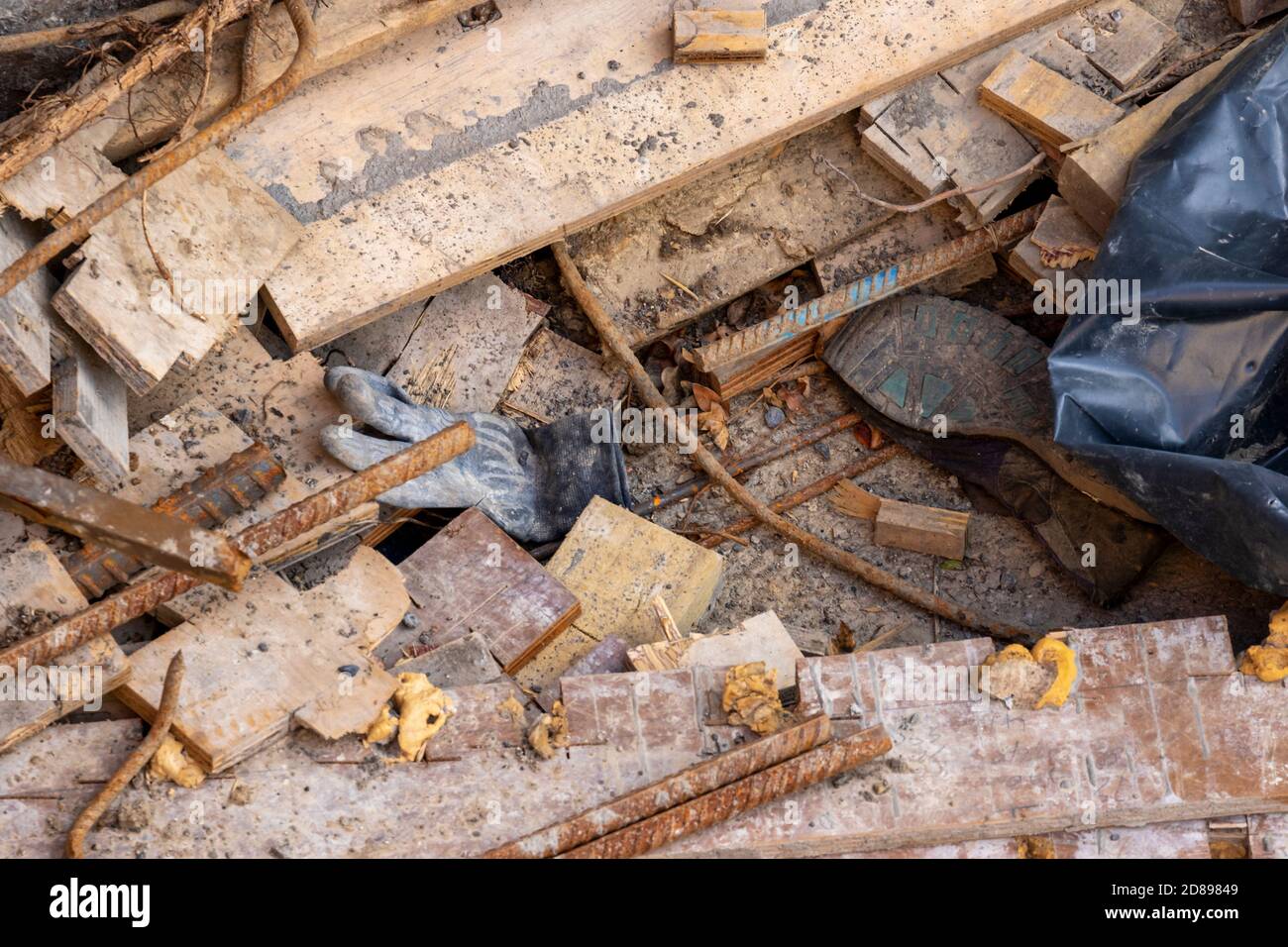 Coupe ou coupe de bois ou de bois sur le chantier de construction, avec tiges en acier métallique et vieux gants et chaussures jetés Banque D'Images