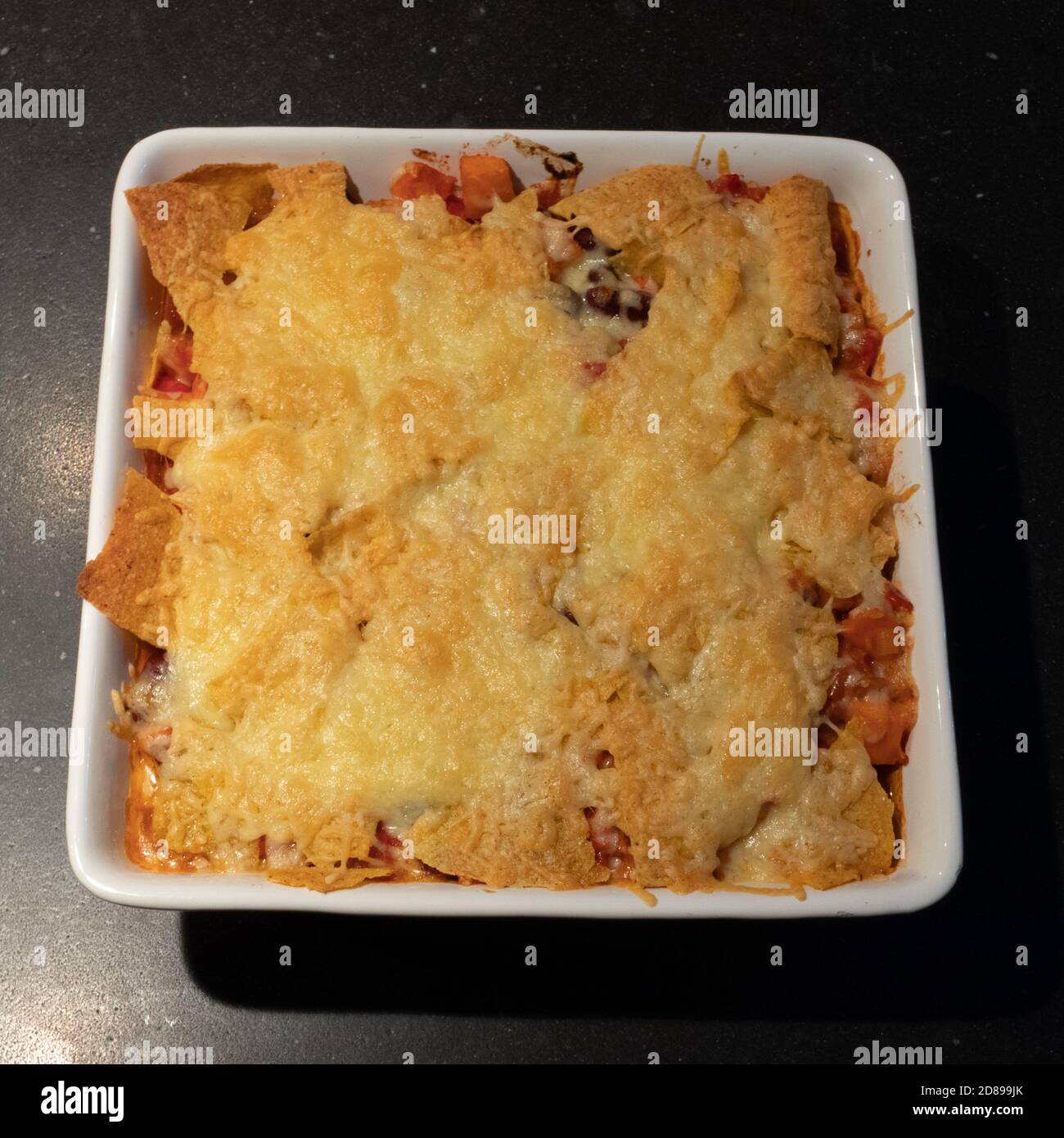 Lasagnes servies dans une assiette blanche au marbre foncé de la table Banque D'Images