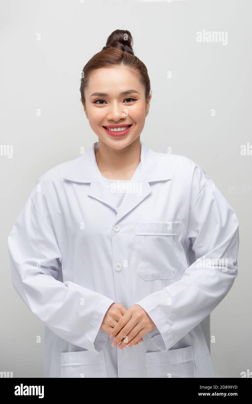 Jeune femme médecin asiatique portant un manteau debout sur un blanc isolé arrière-plan avec un sourire heureux et frais sur le visage Banque D'Images