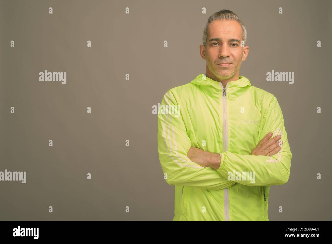 Persan beau homme avec les cheveux gris à l'arrière-plan gris Banque D'Images