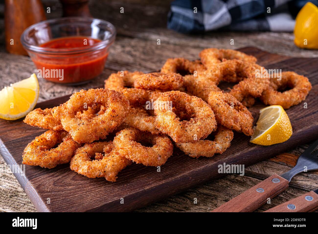 De délicieux panko et des rondelles de calari en croûte de poivre noir avec une sauce piquante à la marinara. Banque D'Images