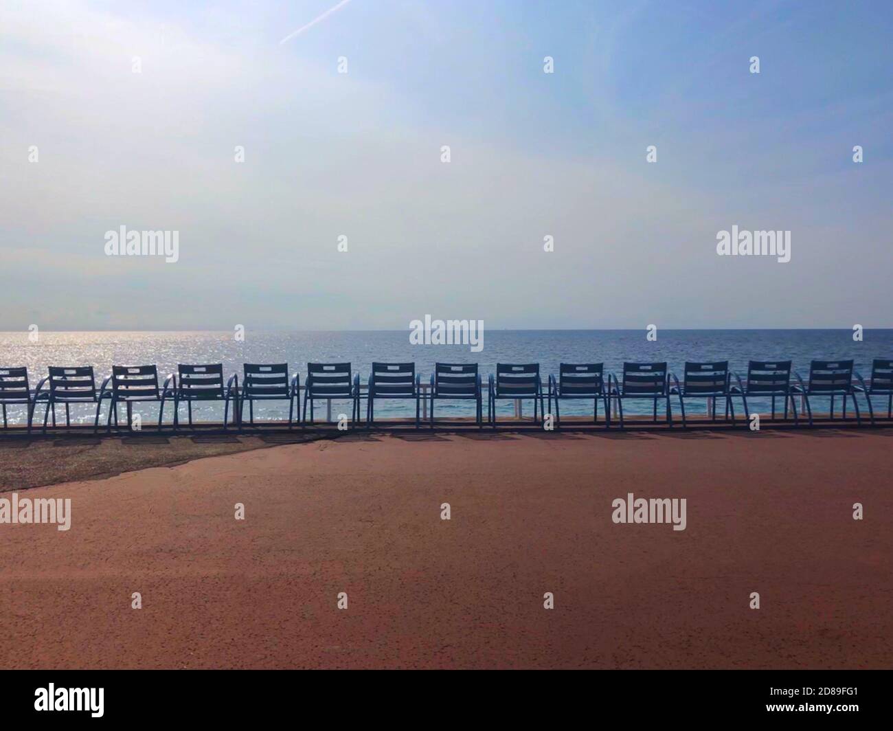 Rangée de chaises métalliques au bord de la mer sur la Promenade des Anglais, Nice, Alpes-Maritimes, France Banque D'Images